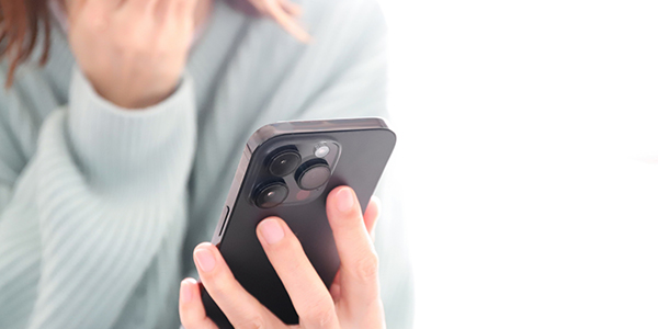 パートナーの浮気を疑いスマホを盗み見る女性